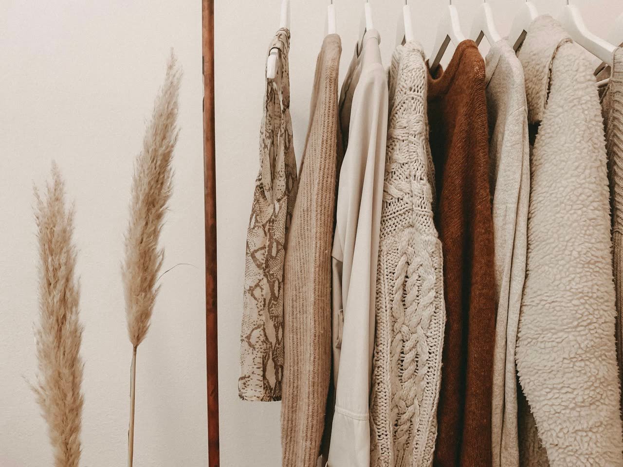 Garments hung on a rail in neutral tones
